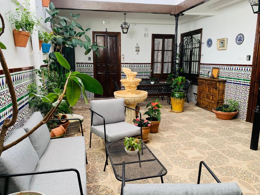 a living room filled with furniture and lots of plants at Apartamentos La Casa del Azafrán in Córdoba
