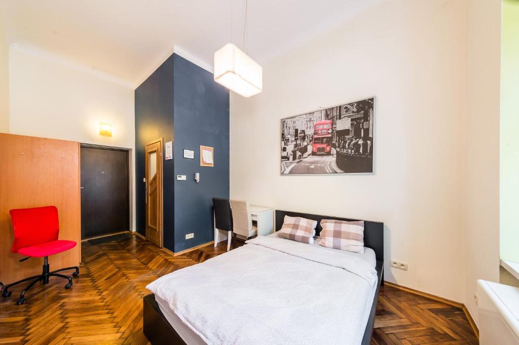 a bedroom with a bed and a red chair at Mrówka in Kraków