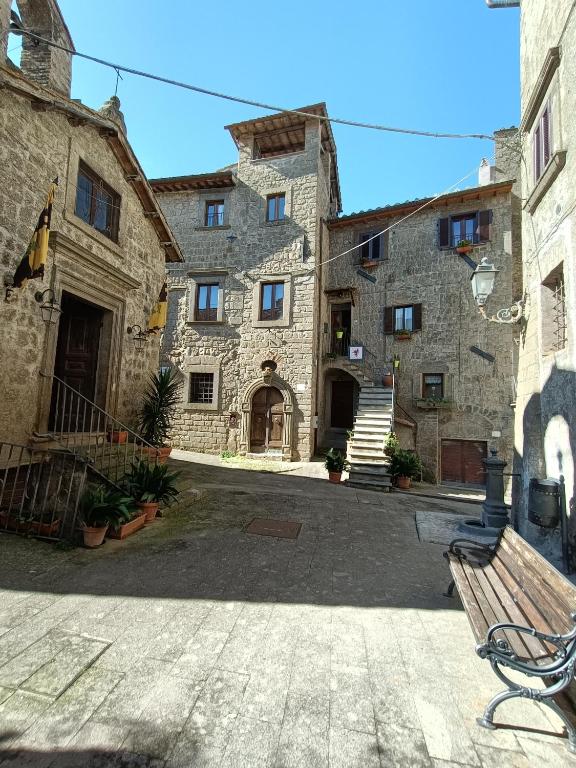 una panchina seduta di fronte a un edificio in pietra di B&B Il Grifo a Bomarzo