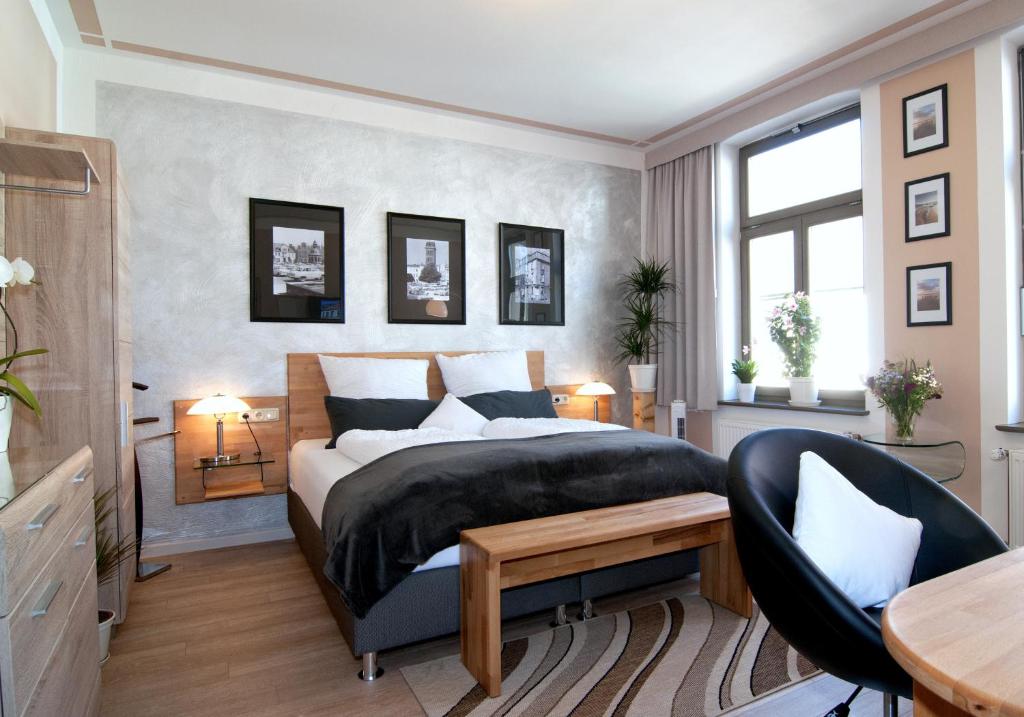 a bedroom with a bed and a desk and a chair at Pension "Westphal's" in Wismar