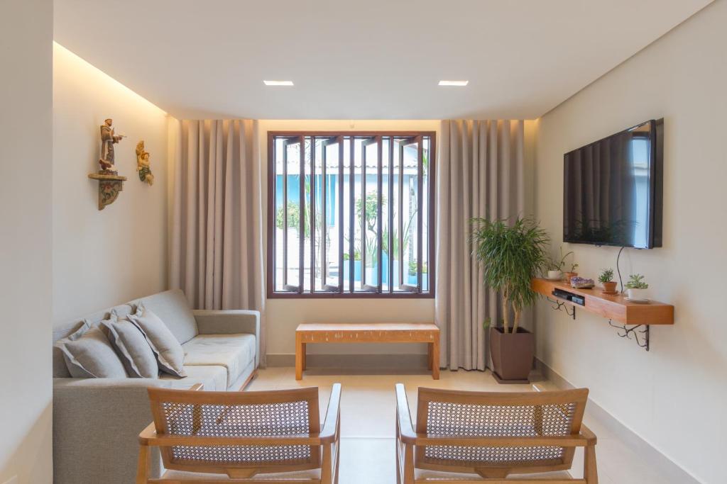 a living room with a couch and a tv at Pousada da Chácara in Mariana