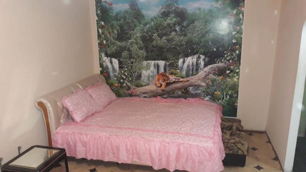 a bedroom with a bed with a painting on the wall at Апартаменти повністю whole apartment in Kryvyi Rih