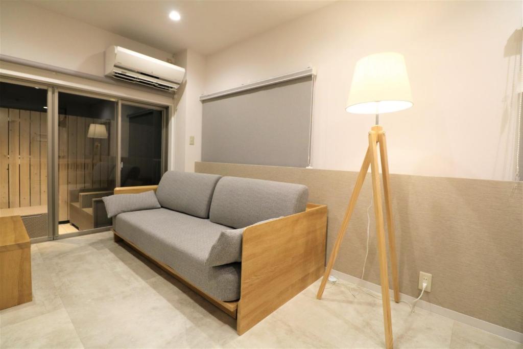 a living room with a couch and a lamp at Smart Stay Ito 302 - Vacation STAY 98471 in Ito