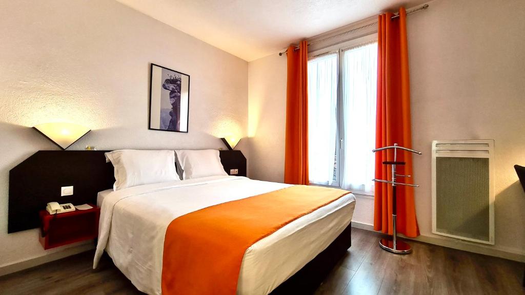 a bedroom with a large bed and a large window at Boulogne Résidence Hotel in Boulogne-Billancourt