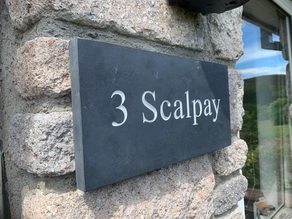 a sign for seayday on a stone wall at Scalpay@Knock View Apartments, Sleat, Isle of Skye in Teangue
