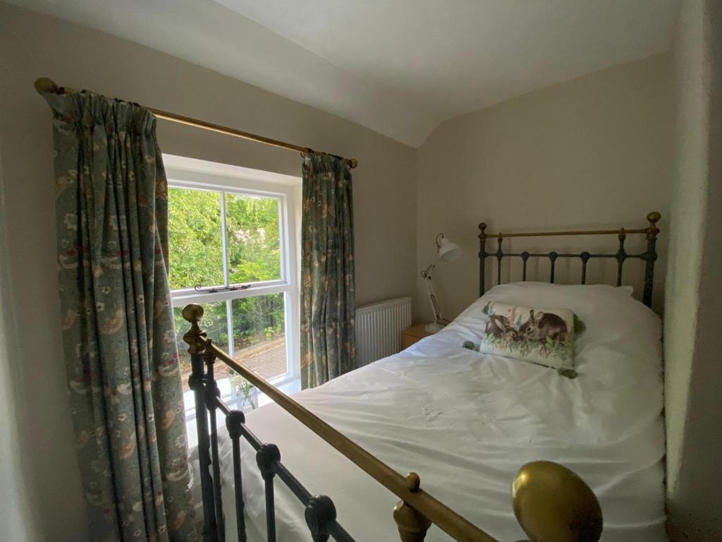 a bedroom with a bed and a window at Bondgate Holiday Cottage in Durham