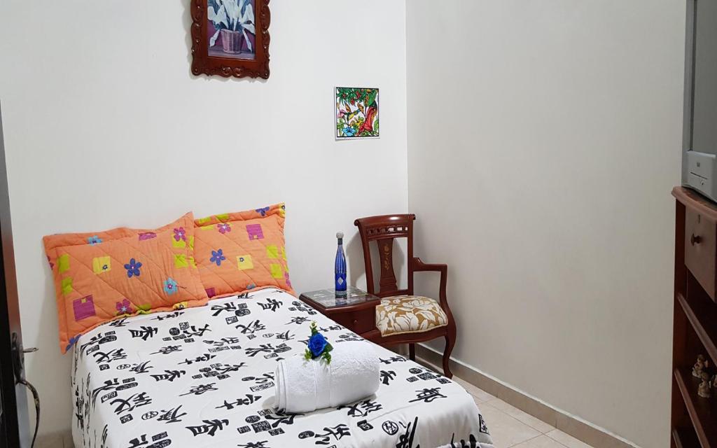 a bedroom with a bed and a chair at Habitación Ciudad Cariño in El Cerrito