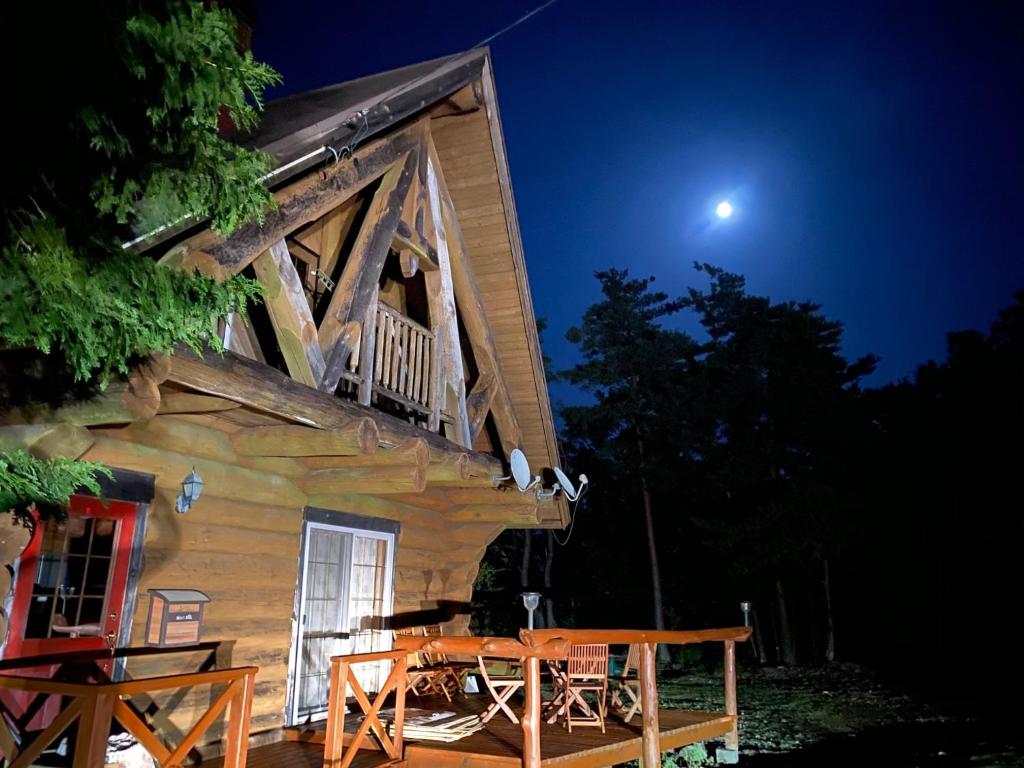 Ise Forest villa - Vacation STAY 9557 في إيسي: كابينة خشب في الليل مع القمر في السماء