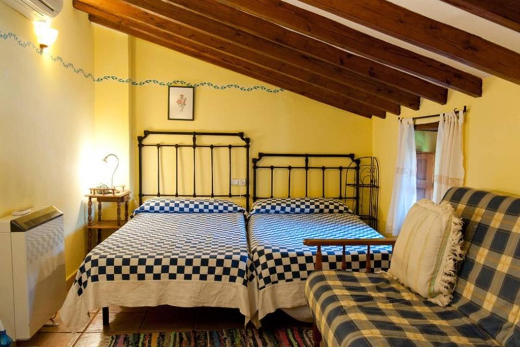 a bedroom with two beds and a couch at Studio with balcony and wifi at Robledillo de Gata in Robledillo de Gata