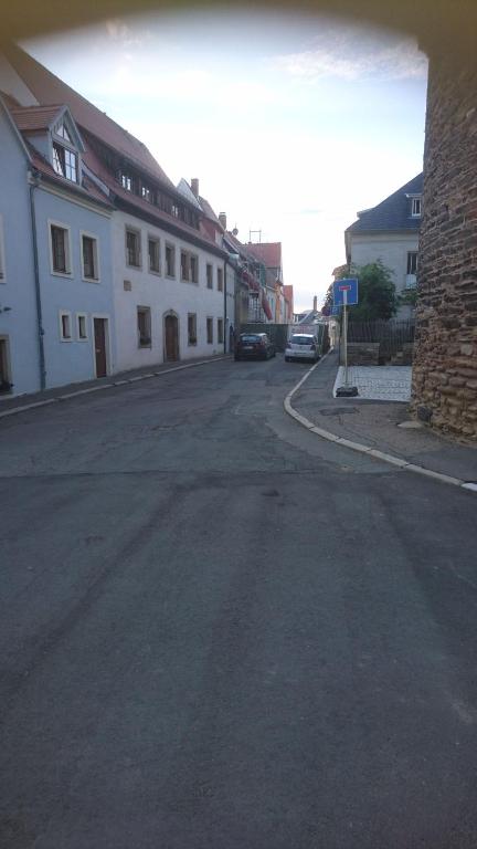 una strada vuota con auto parcheggiate sul lato di un edificio di Haus am Donatsturm a Freiberg