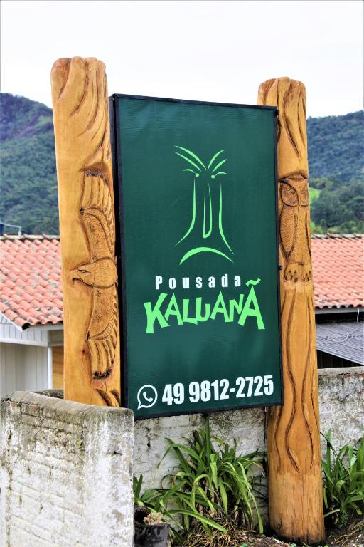 a sign for a restaurant with a palm tree on it at Pousada Kaluana in Urubici