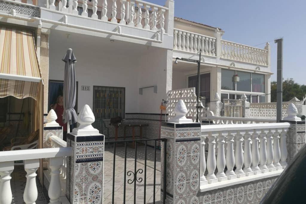 una cerca blanca con un paraguas en la parte superior de una casa en Bungalov u Růžové laguny, en Torrevieja