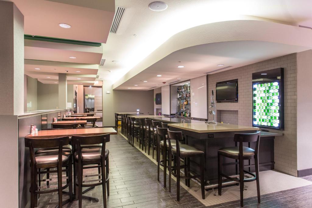 a bar in a restaurant with bar stools at Holiday Inn Texarkana Arkansas Convention Center by IHG in Texarkana