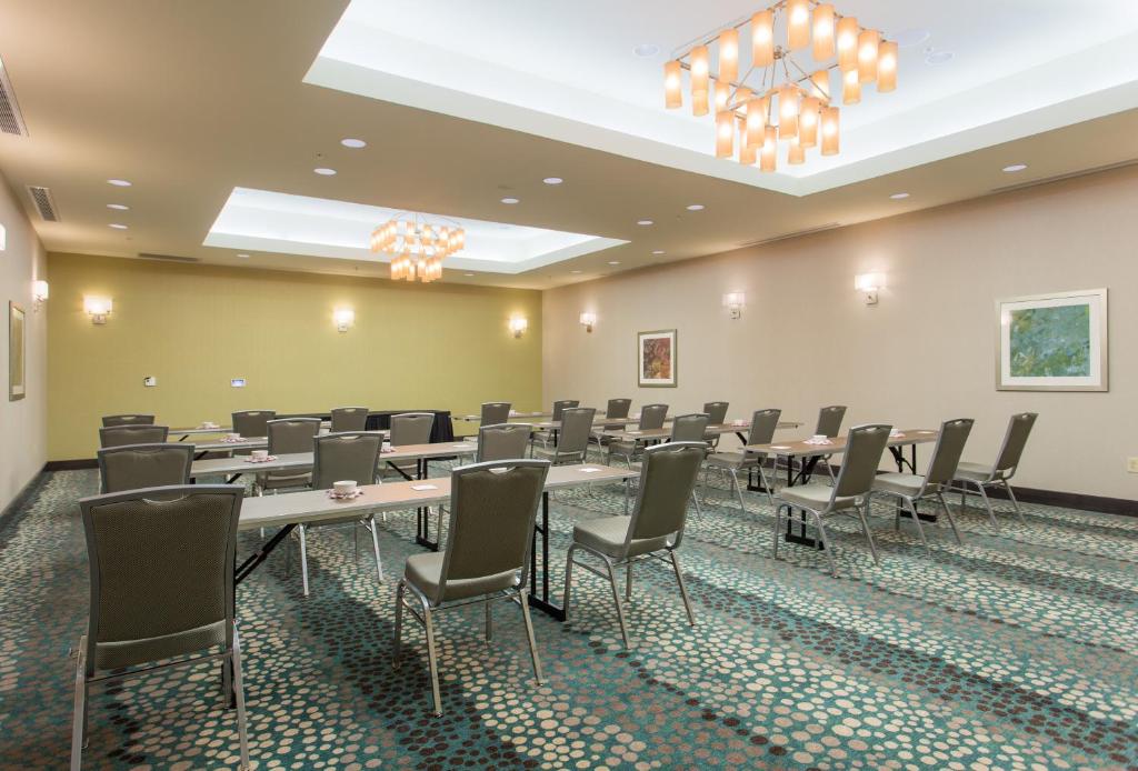 a conference room with tables and chairs and a chandelier at Holiday Inn Texarkana Arkansas Convention Center by IHG in Texarkana
