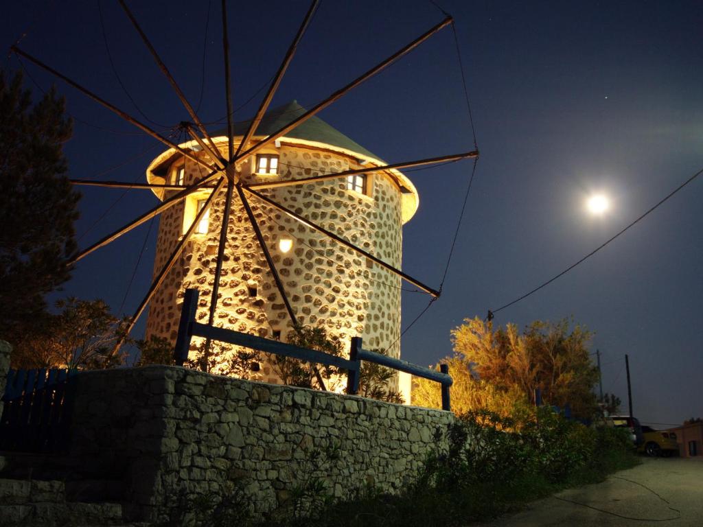 a building with a windmill at night at Windmill Studios in Livadi