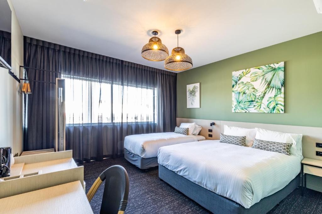 a hotel room with two beds and a desk at Nightcap at Commercial Hotel in Gold Coast