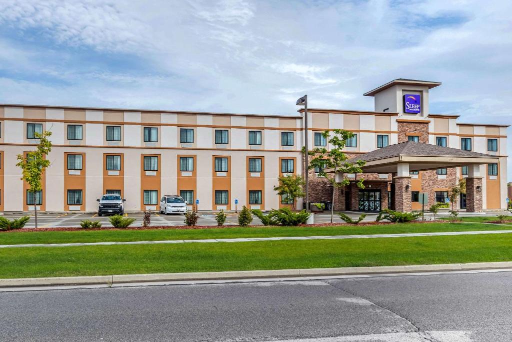 a large building with a parking lot in front of it at Sleep Inn & Suites Ames near ISU Campus in Ames