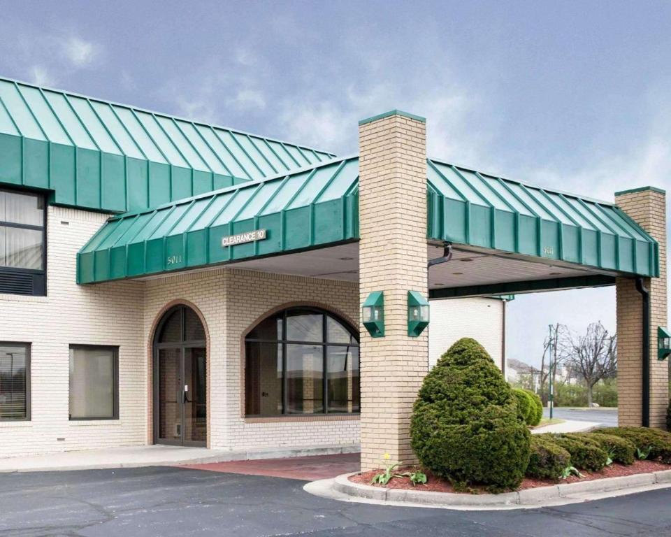 a building with a green awning in a parking lot at Quality Inn and Suites Indianapolis in Indianapolis