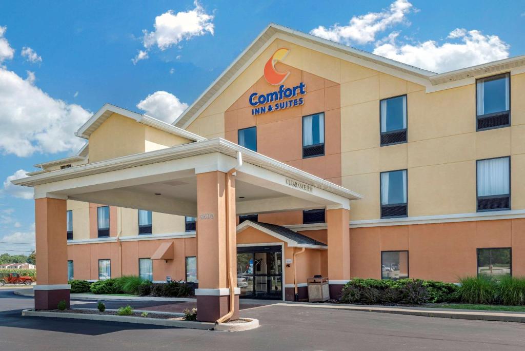 un hotel con un cartel en la parte delantera de un edificio en Comfort Inn & Suites, en Muncie