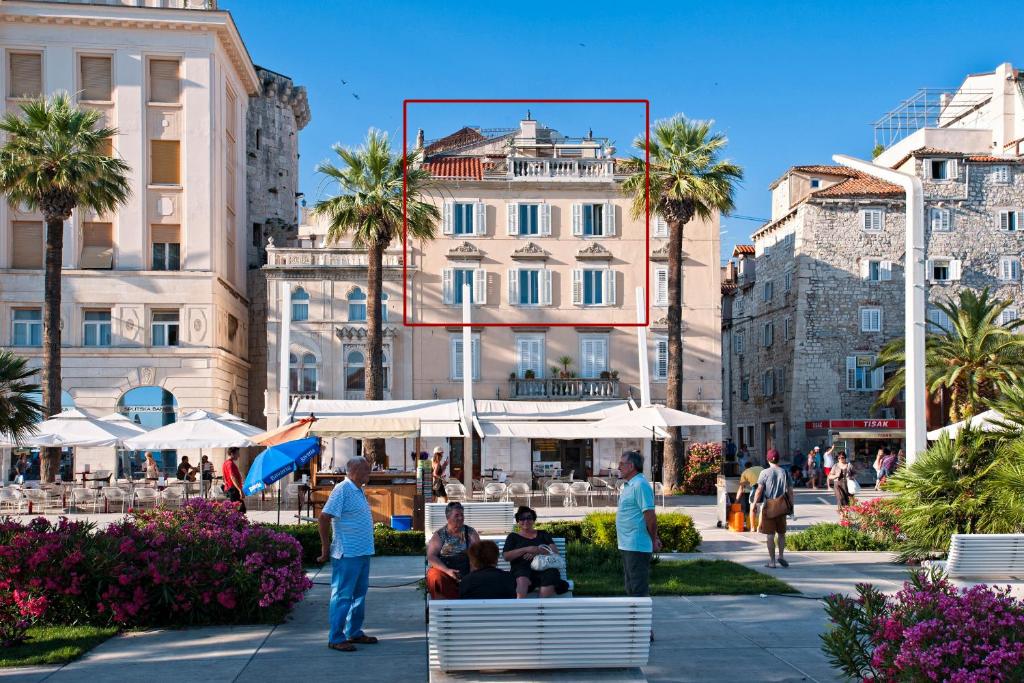 Un gruppo di persone seduti su una panchina in una citta' di Riva Luxury Suites a Spalato (Split)