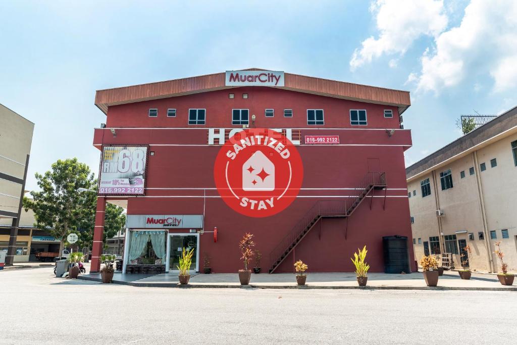 czerwony budynek z napisem na boku w obiekcie Super OYO 756 Muar City Hotel w mieście Muar