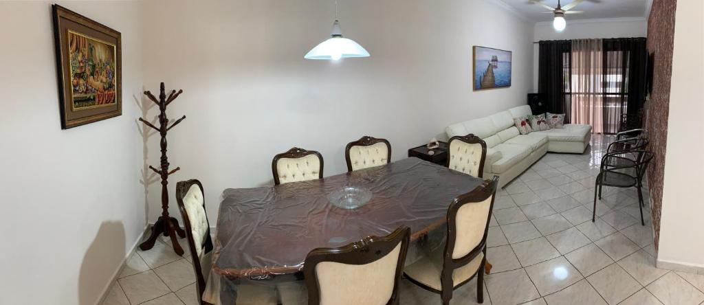 a dining table and chairs in a living room at Guarujá Enseada in Guarujá