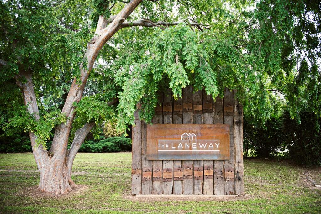 a wooden gate with a sign that reads the leave way at The Laneway in Mudgee