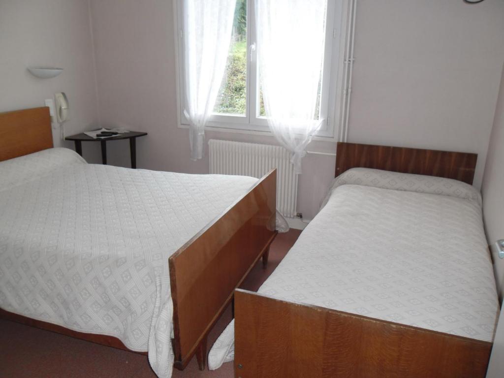 - 2 lits dans une petite chambre avec fenêtre dans l'établissement Hotel de L'Hippodrome, à Arnac-Pompadour