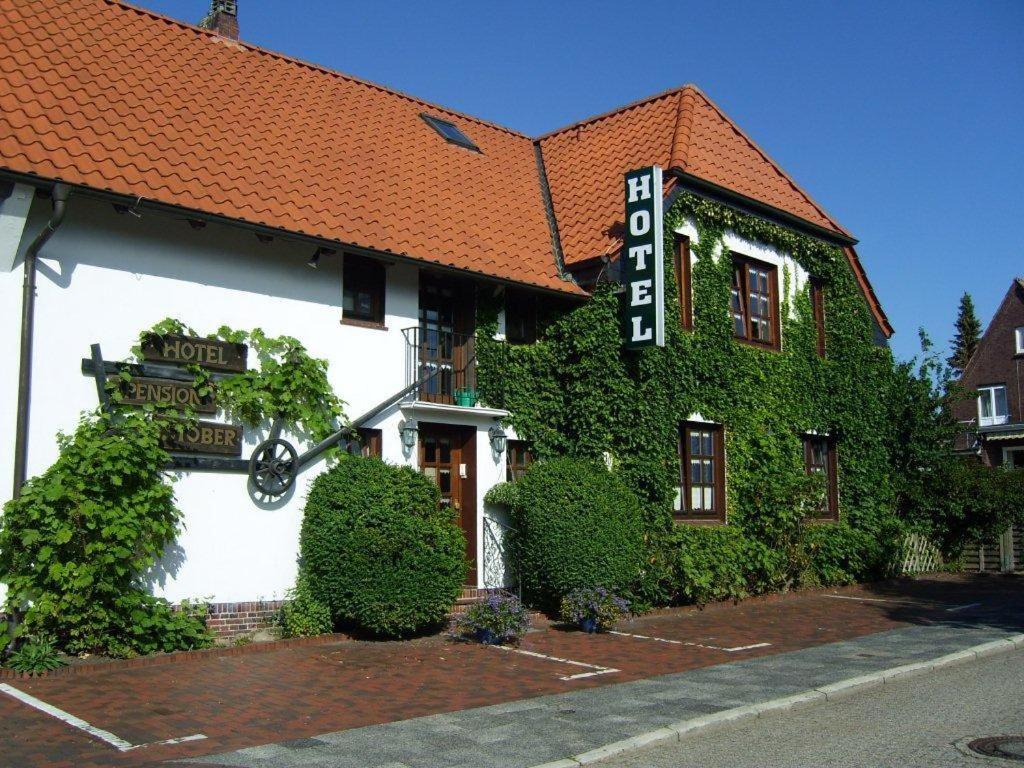 un bâtiment avec du lierre sur son côté dans l'établissement Hotel-Pension Stöber, à Jever