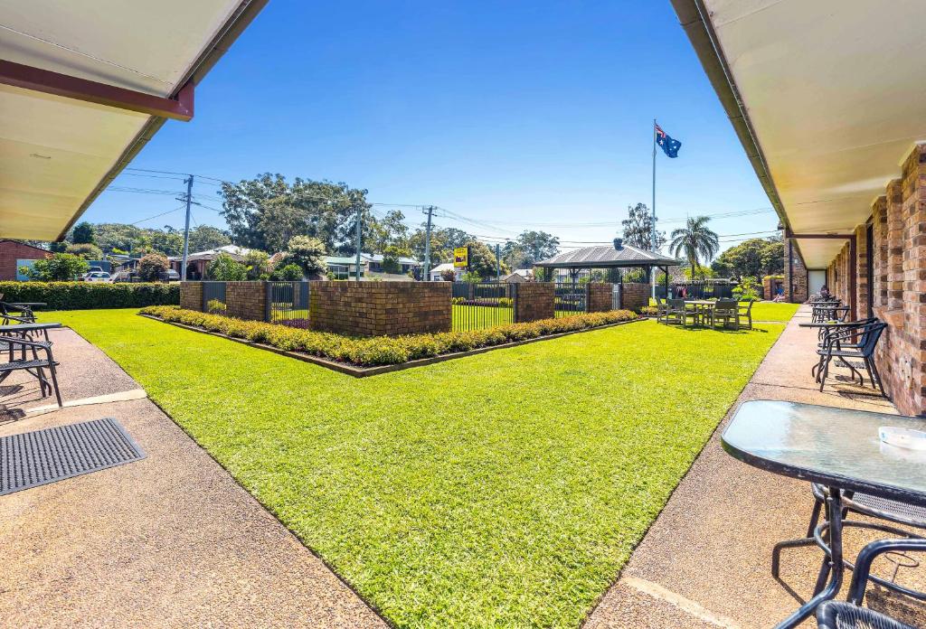 a yard with a lawn with tables and chairs at Lemon Tree Passage Motel in Lemon Tree Passage