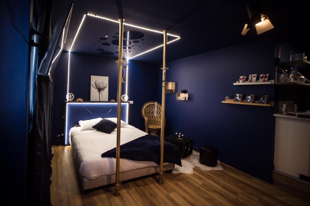 sypialnia z łóżkiem z baldachimem w niebieskim pokoju w obiekcie Suite 50 Nuances avec Balnéothérapie pour 2 w Caen
