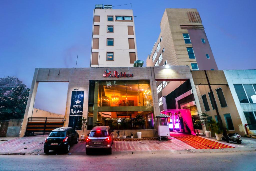 a building with cars parked in front of a store at Hotel Rajshree & Spa in Chandīgarh