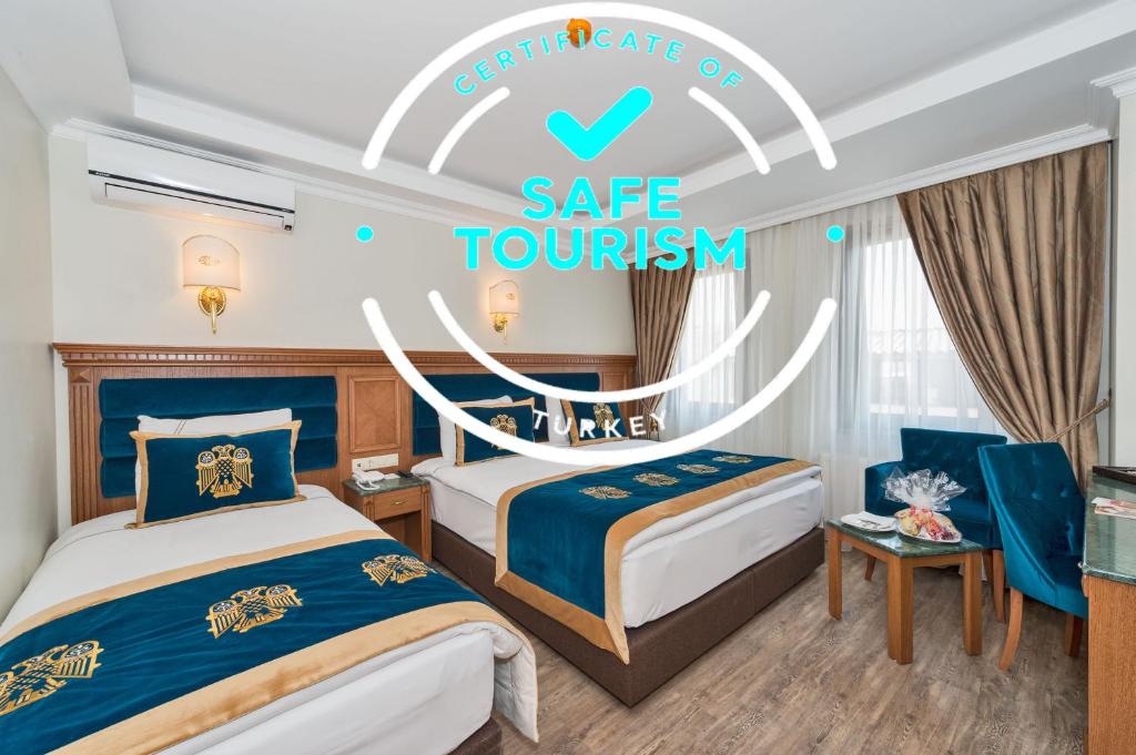 イスタンブールにあるByzantium Comfort Hotelのベッド2台と安全な観光のサインが備わるホテルルームです。