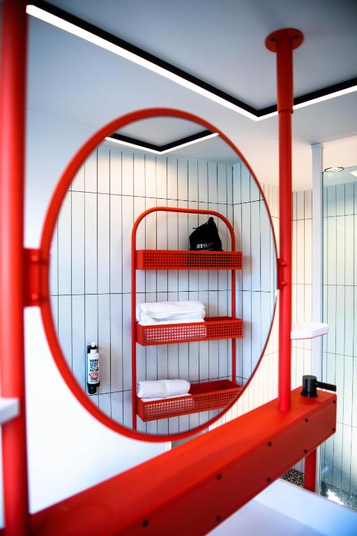 a red shelf with three folded towels in a room at YOU Are Deauville in Deauville