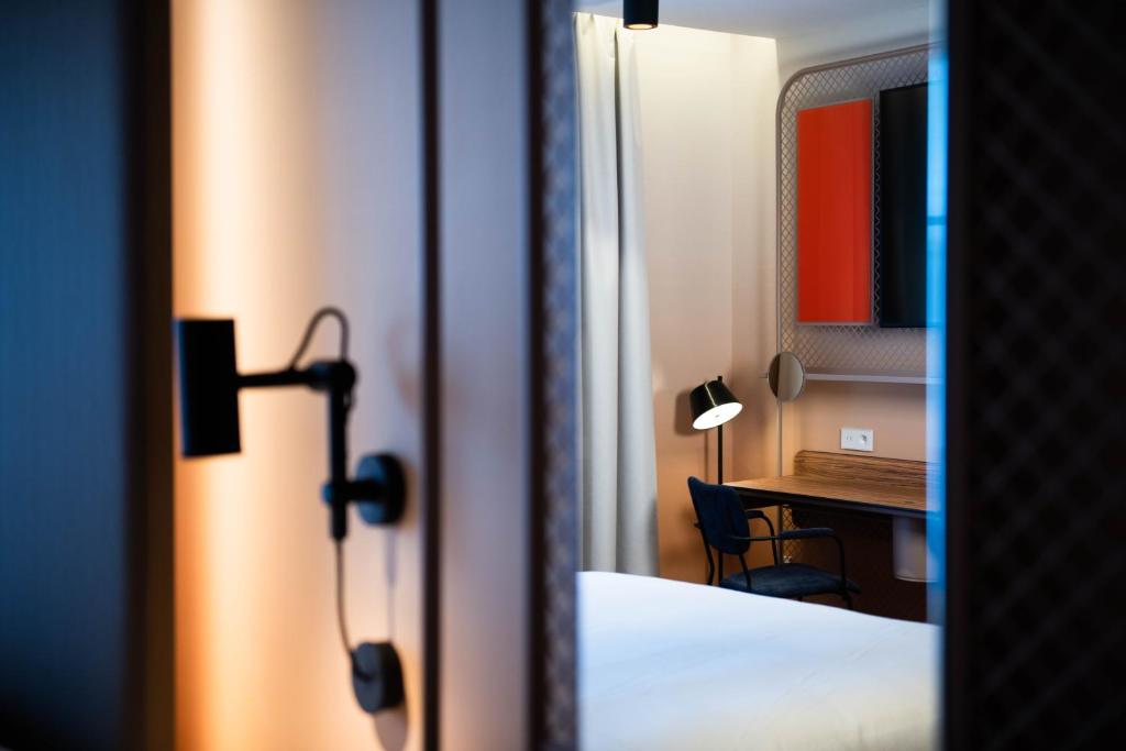 a room with a bedroom with a desk and a bed at YOU Are Deauville in Deauville