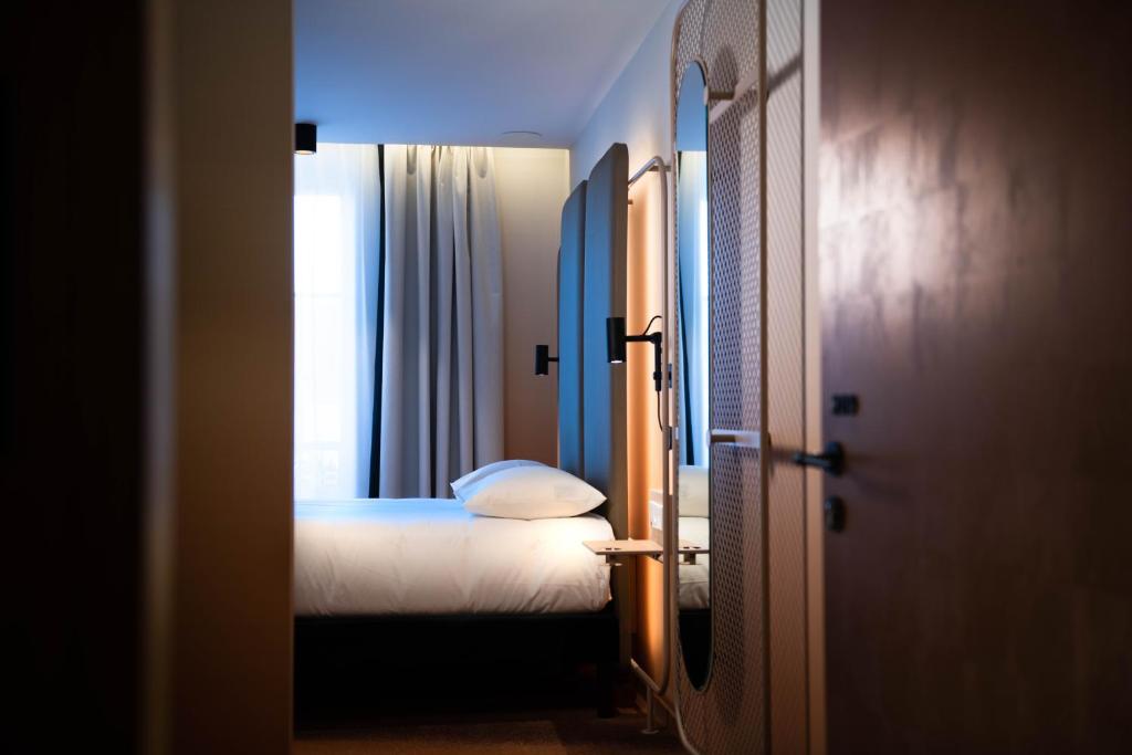 a small bedroom with a bed and a window at YOU Are Deauville in Deauville