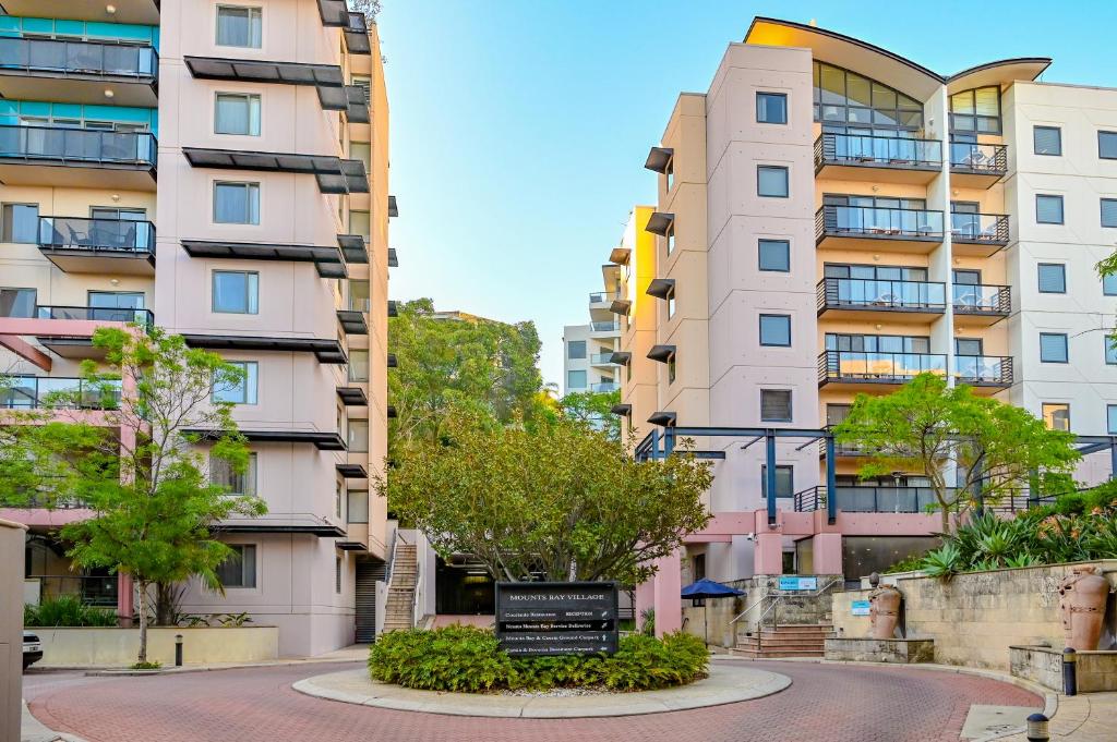 une rue dans une ville avec de grands bâtiments dans l'établissement Nesuto Mounts Bay, à Perth