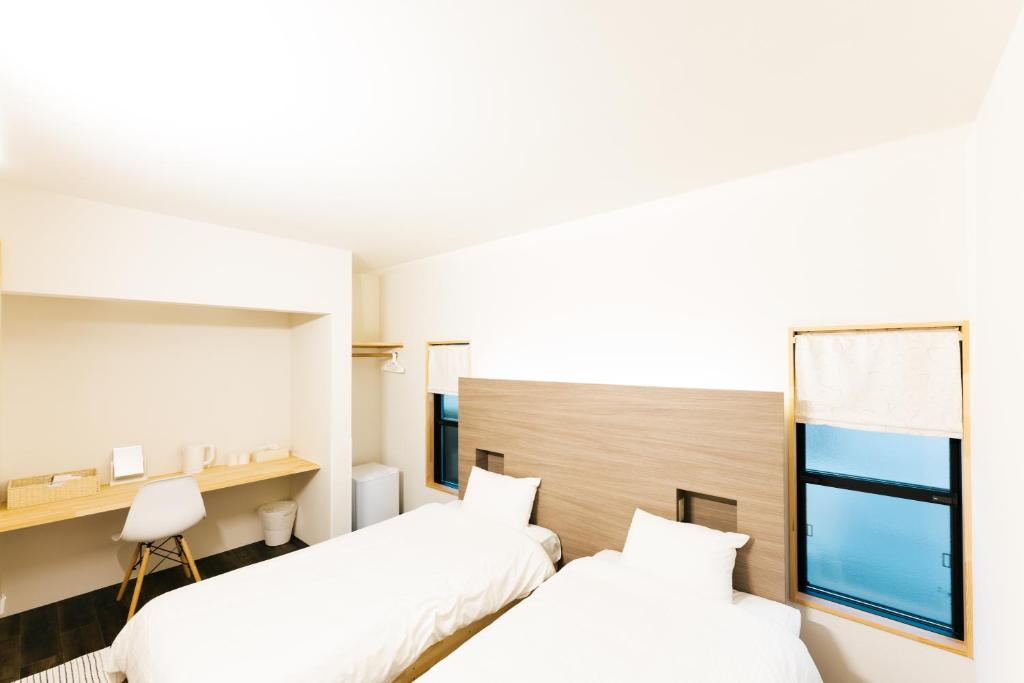 a hotel room with two beds and a window at B&B MIKAWA Info Centre - Kanazawa Fish Harbour in Kanazawa