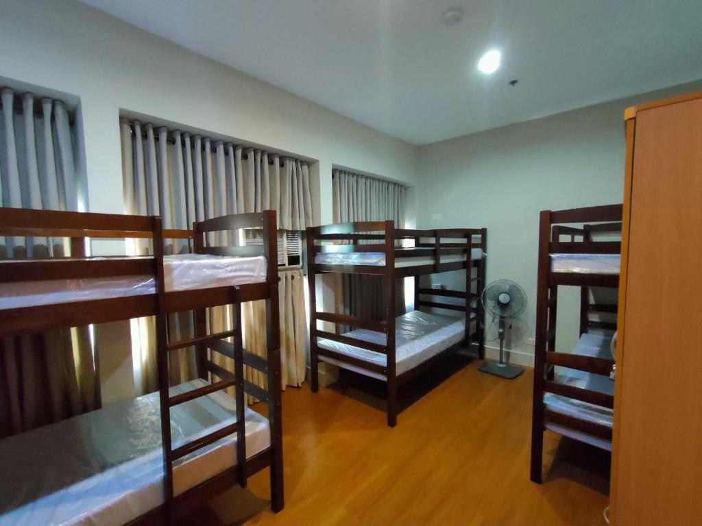 a room with three bunk beds in a room at 538 Dormitel in Manila