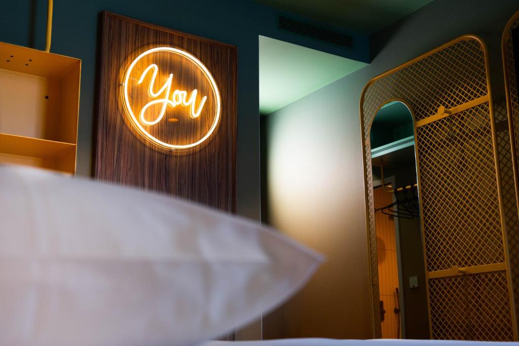 a neon sign on a wall in a room at YOU Are Deauville in Deauville