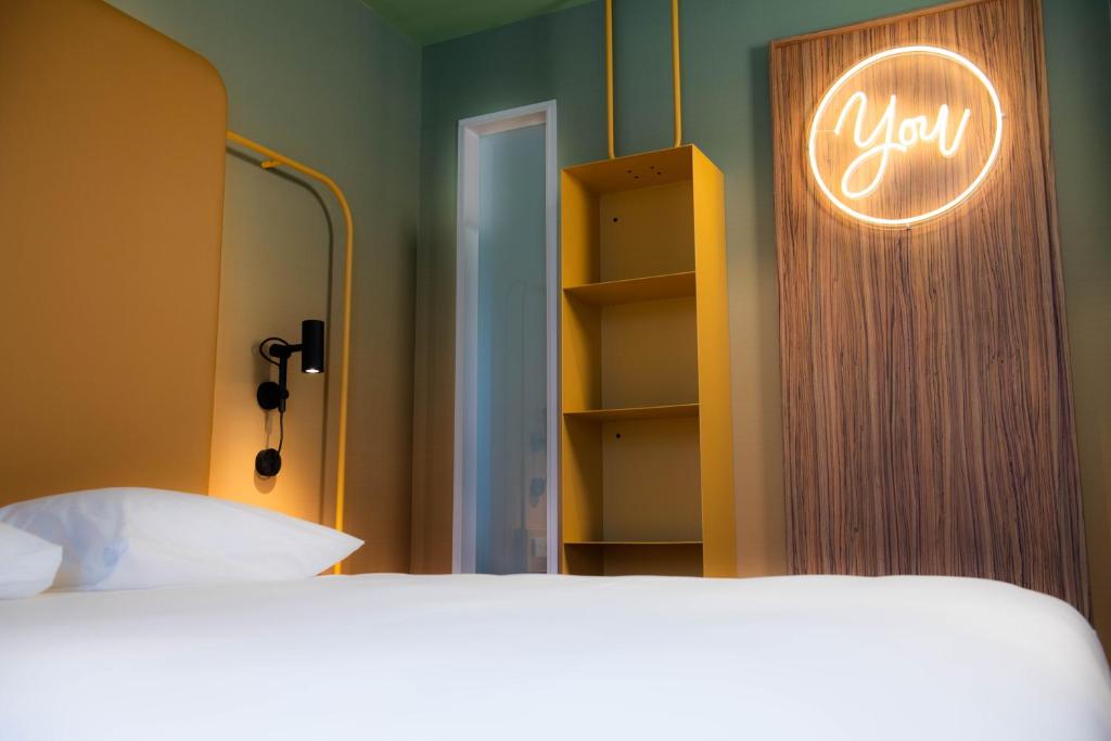 a bedroom with a bed and a sign that says you at YOU Are Deauville in Deauville
