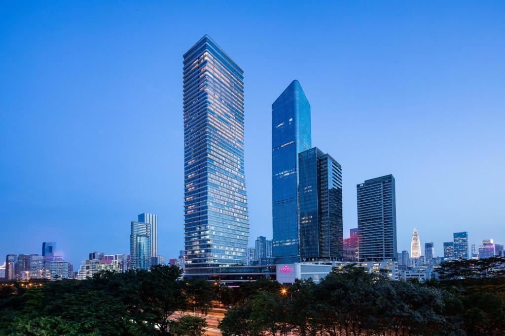 eine Gruppe großer Gebäude in einer Stadt in der Unterkunft Crowne Plaza Shenzhen Nanshan, an IHG Hotel in Shenzhen