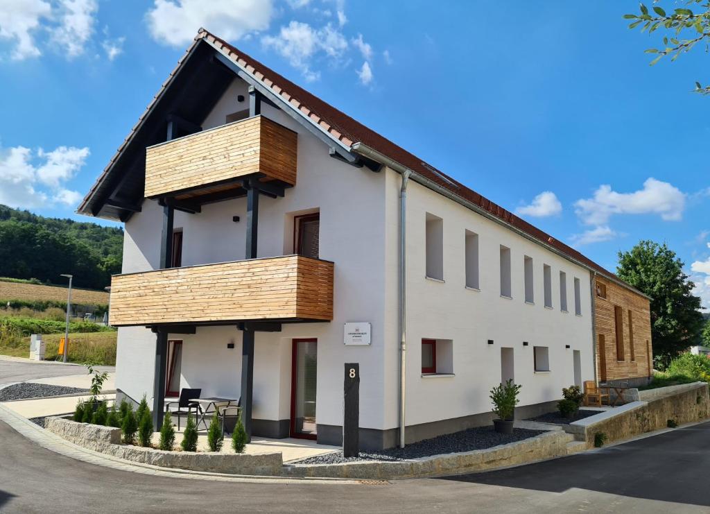 a white house with a black roof at wohnung-nummer-1 in Pielenhofen