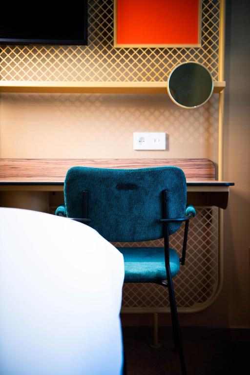 a blue chair sitting in front of a desk at YOU Are Deauville in Deauville