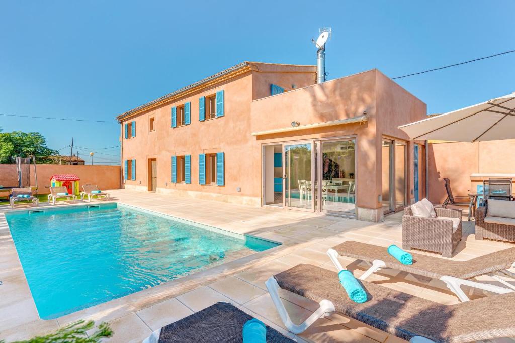 a swimming pool with chairs and a house at Ca na Rossa in Sineu