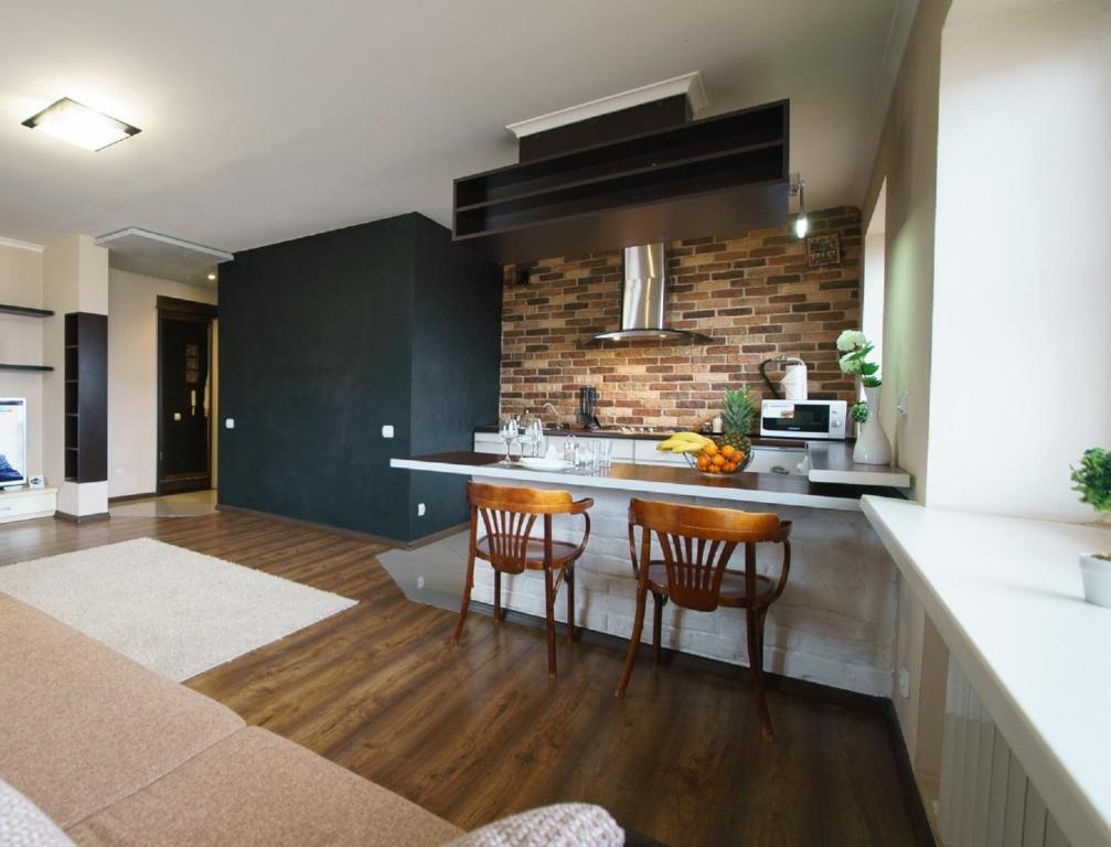a kitchen with two bar stools and a brick wall at PaulMarie Apartments on Boldina in Mogilev