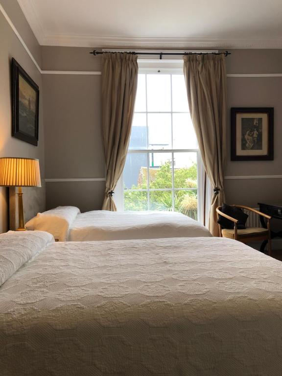 1 dormitorio con 2 camas y ventana en Harveys Guest House, en Dublín