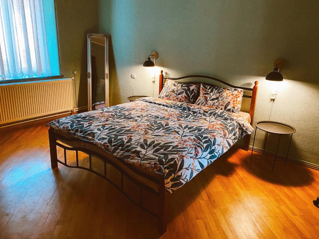 1 dormitorio con 1 cama grande y suelo de madera en Corner Guest House en Tiflis