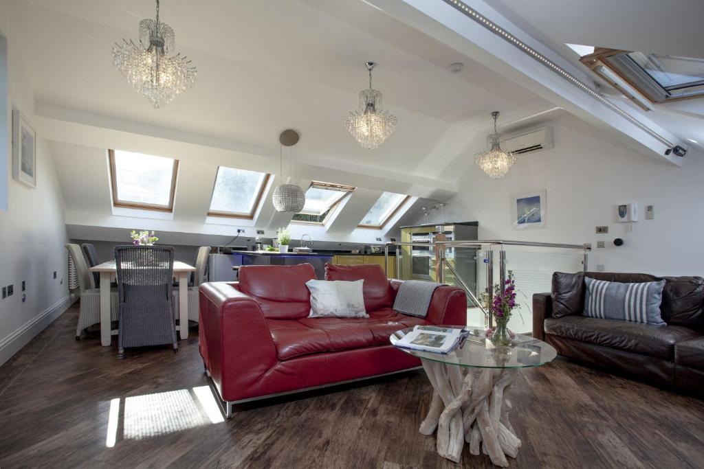 a living room with a red couch and a table at The Penthouse 15 At the Beach, Torcross in Beesands