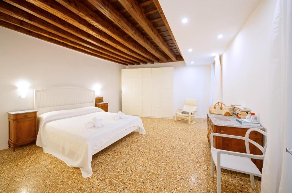 - une chambre avec un lit blanc et une table en bois dans l'établissement DolceVita Apartments N. 479, à Venise